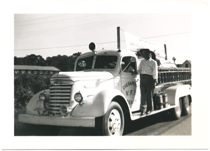 A man (unknown) standing on the side rail of the Chesapeake Beach Volunteer Fire Department (CBVFD) Truck about 1945, pumper_truck_cbvf_lv-fire-chesapeake.jpg